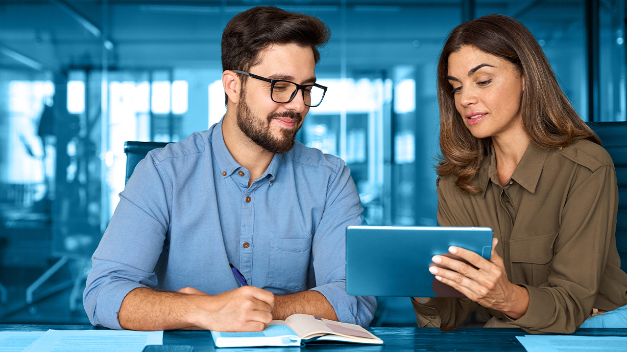 Team members reviewing release notes on tablet at desk